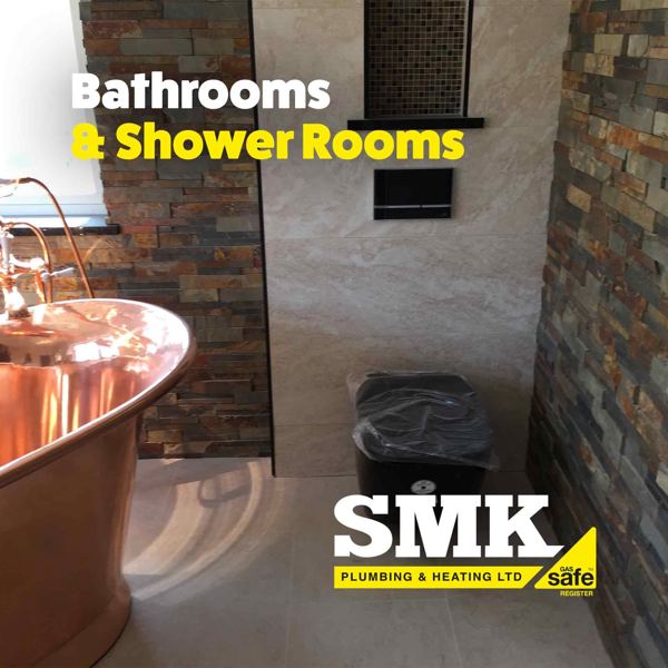 Shower room with a copper bath and slate feature wall