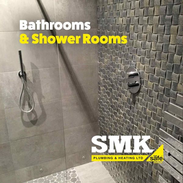 Walk-in shower with a handset and textured tile wall