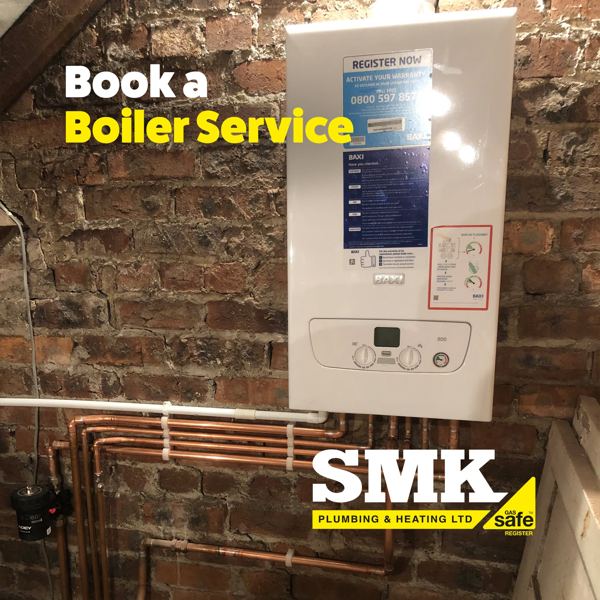 Wall-hung combi boiler on exposed brick with copper pipework