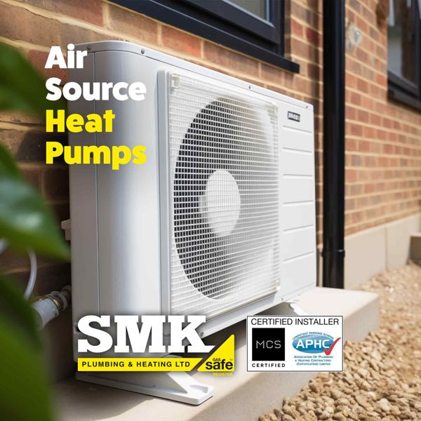 Air source heat pump on a concrete base beside a brick house