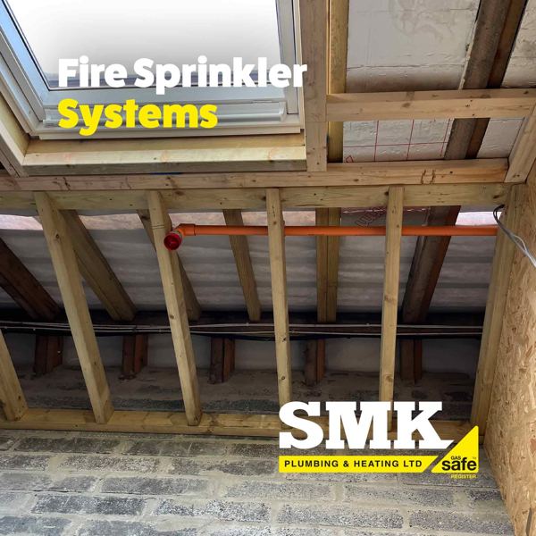 Orange sprinkler pipes running along the joists of a loft